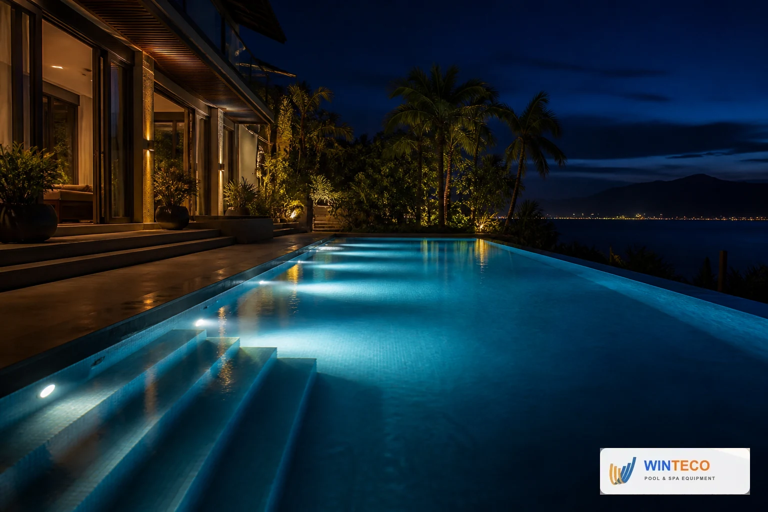 Hồ bơi villa Nha Trang về đêm với đèn âm nước xanh và ánh sáng kiến trúc màu ấm